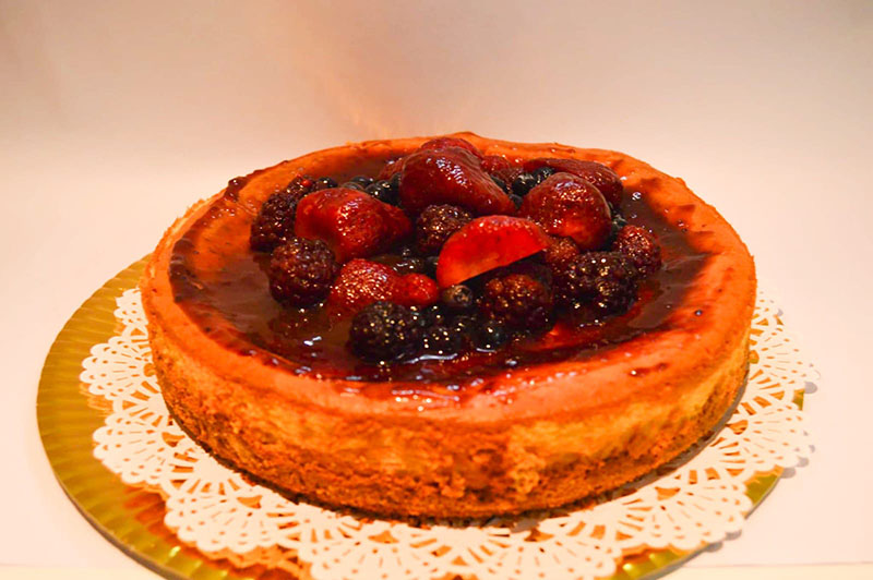 imagen de Cheesecake con base de galletitas de vainilla decorado con una mermelada de frutos rojos más frutos rojos