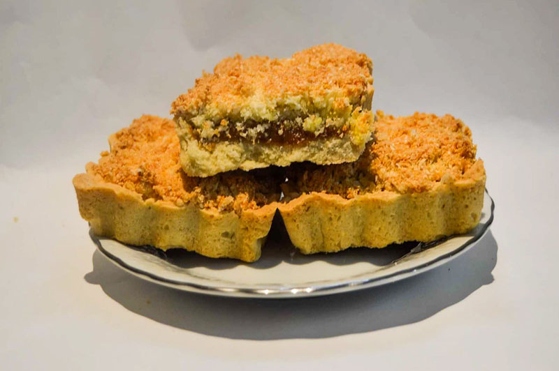 Masa sable con relleno de dulce de leche, cubierto con coco y azúcar